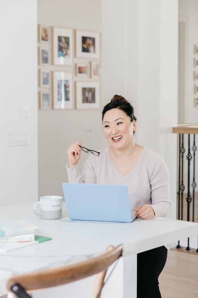 woman seated at table with open laptop